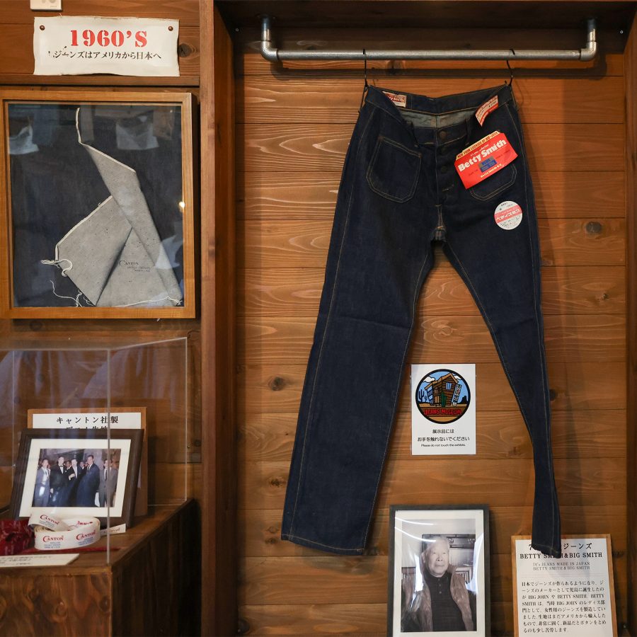 A pair of Betty Jeans denim trousers hanging up at an exhibition.  
